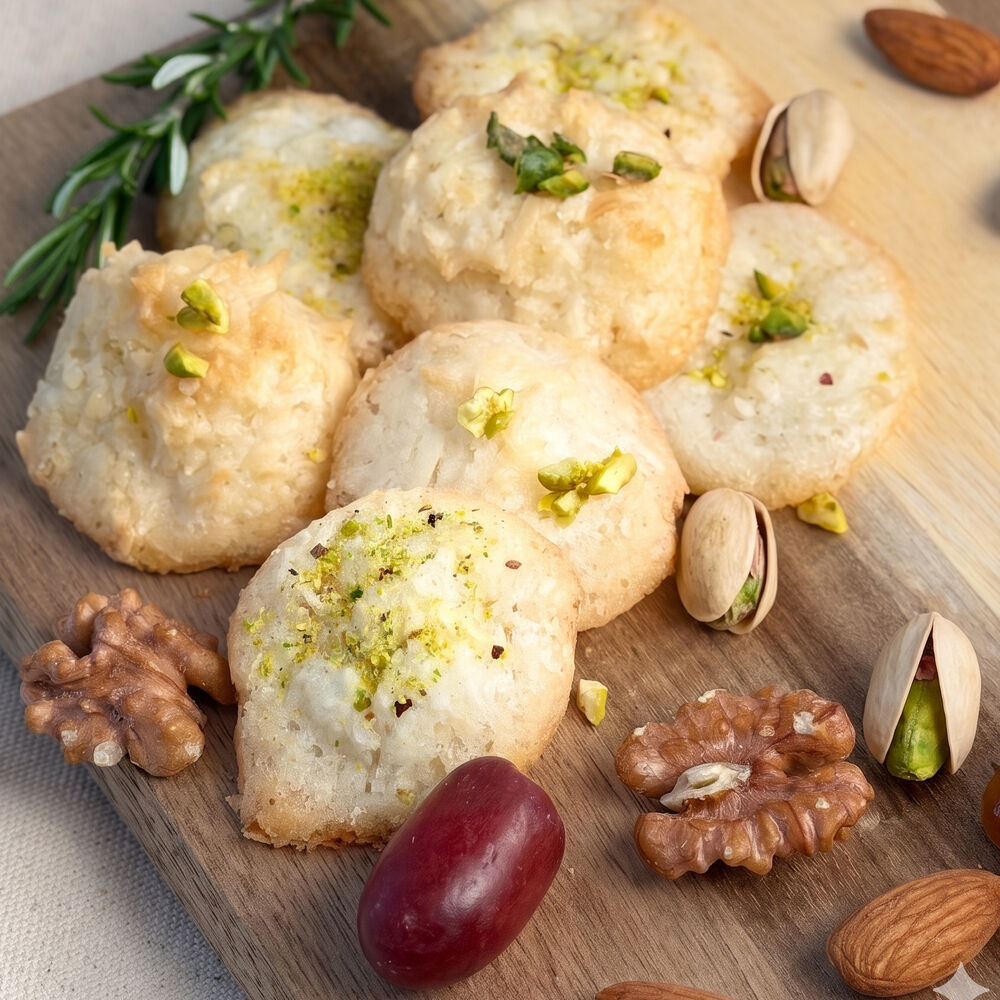 Golden coconut macaroons dusted with pistachio on a wooden board — Honey & Fig Bakery, Pflugerville, Texas